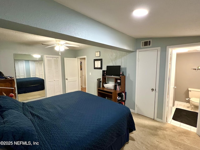 457 Nightingale Rd, Jacksonville, FL 32216 - bedroom with light colored carpet, connected bathroom, two closets, and a ceiling fan