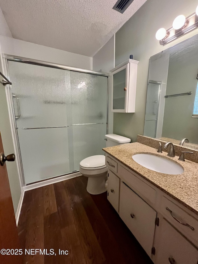 118 Magnolia Dr, East Palatka, FL 32131 - bathroom featuring wood finished floors, vanity, a shower stall, and a textured ceiling