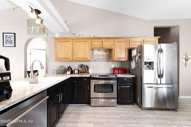 2875 Majestic Oaks Ln, Green Cove Springs, FL 32043 - kitchen with appliances with stainless steel finishes, light stone countertops, arched walkways, and light brown cabinets