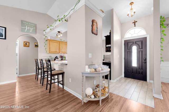 2875 Majestic Oaks Ln, Green Cove Springs, FL 32043 - entrance foyer featuring high vaulted ceiling, light wood-style flooring, arched walkways, and a chandelier