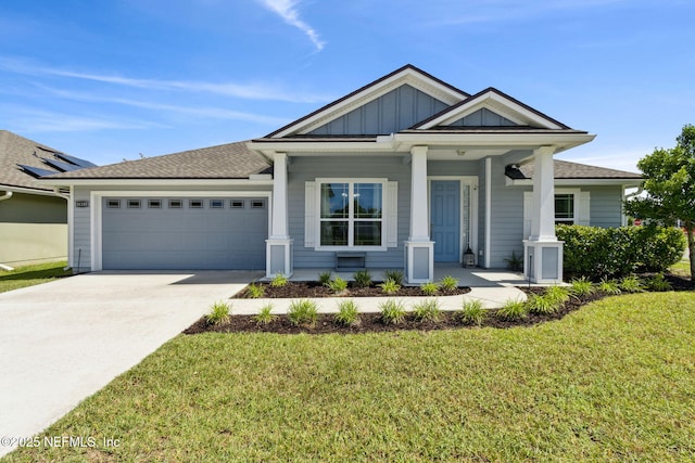 86180 Tranquil Ct, Yulee, FL 32097 - view of front of property featuring an attached garage, driveway, a front yard, board and batten siding, and covered porch