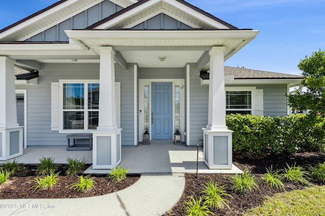 86180 Tranquil Ct, Yulee, FL 32097 - view of exterior entry with covered porch, board and batten siding, and a shingled roof