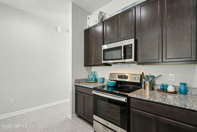 86180 Tranquil Ct, Yulee, FL 32097 - kitchen featuring appliances with stainless steel finishes, dark brown cabinetry, and light stone counters