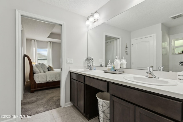 86180 Tranquil Ct, Yulee, FL 32097 - full bath featuring double vanity, healthy amount of natural light, tile patterned floors, ensuite bath, and a textured ceiling