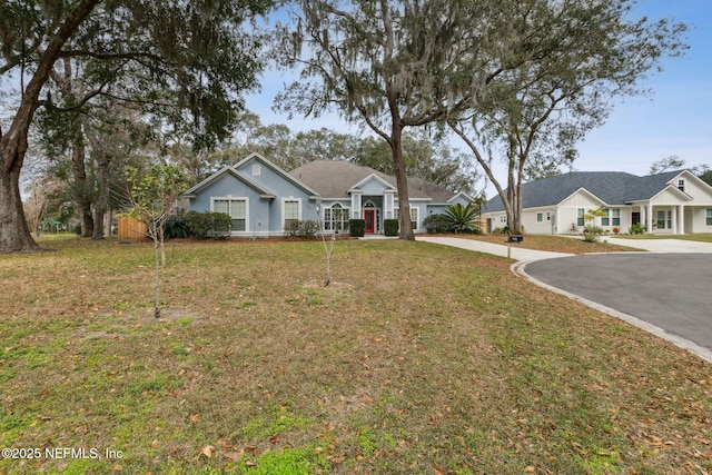 2205 Ashley Ct, Fernandina Beach, FL 32034 - ranch-style home featuring asphalt driveway, a front lawn, and a residential view