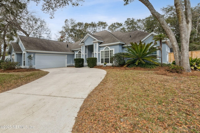 2205 Ashley Ct, Fernandina Beach, FL 32034 - greek revival inspired property featuring driveway, a garage, stucco siding, and a shingled roof