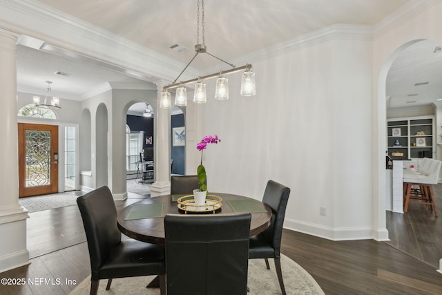 2205 Ashley Ct, Fernandina Beach, FL 32034 - dining area featuring arched walkways, wood finished floors, crown molding, and decorative columns