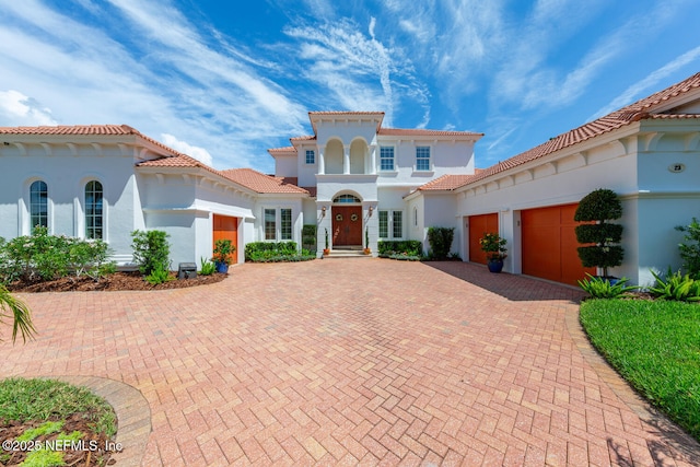 23 Corona Rd, Ponte Vedra Beach, FL 32082 - mediterranean / spanish-style home featuring an attached garage, decorative driveway, stucco siding, and a tile roof