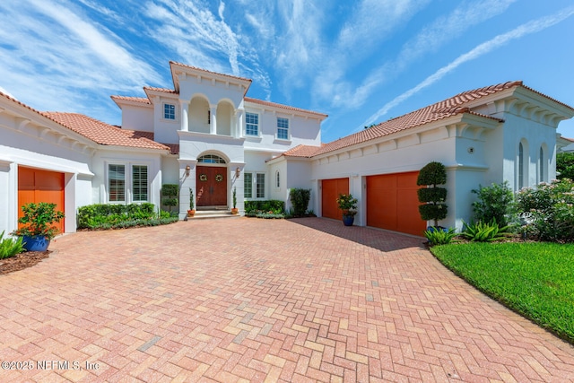 23 Corona Rd, Ponte Vedra Beach, FL 32082 - mediterranean / spanish home featuring an attached garage, decorative driveway, stucco siding, and a tiled roof