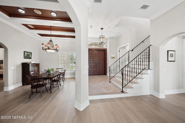 23 Corona Rd, Ponte Vedra Beach, FL 32082 - foyer entrance with light wood finished floors, arched walkways, a chandelier, ornamental molding, and stairway