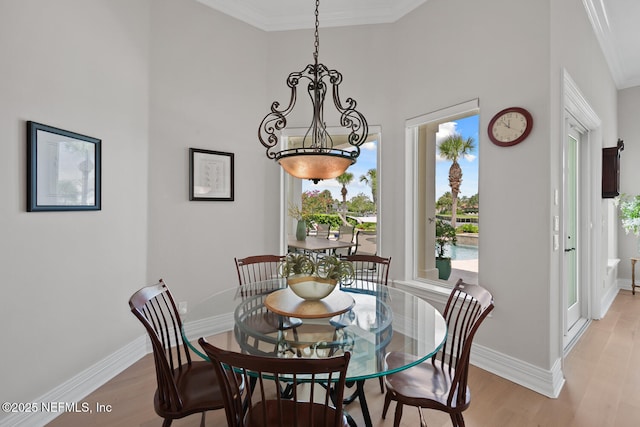 23 Corona Rd, Ponte Vedra Beach, FL 32082 - dining area with light wood-style flooring, ornamental molding, a chandelier, and a towering ceiling