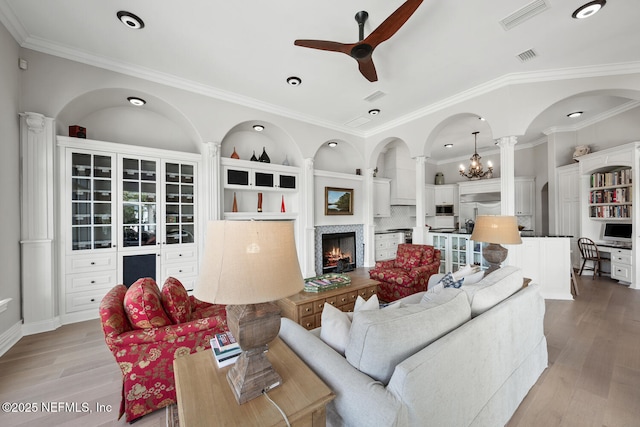 23 Corona Rd, Ponte Vedra Beach, FL 32082 - living room with a ceiling fan, ornate columns, a warm lit fireplace, light wood-type flooring, and ornamental molding