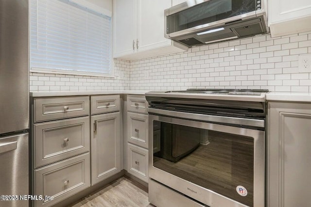 7 Arbor Club Dr Unit 214, Ponte Vedra Beach, FL 32082 - kitchen featuring stainless steel appliances, light countertops, decorative backsplash, light wood-type flooring, and gray cabinetry
