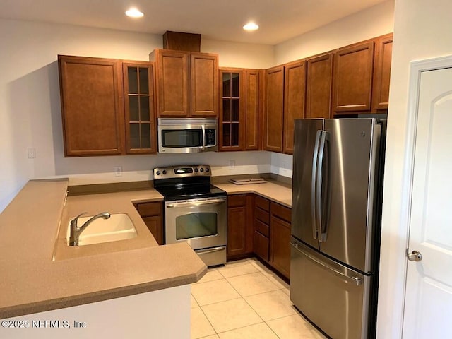 13312 Low Tide Way, Jacksonville, FL 32258 - kitchen with appliances with stainless steel finishes, glass insert cabinets, light tile patterned flooring, light countertops, and recessed lighting