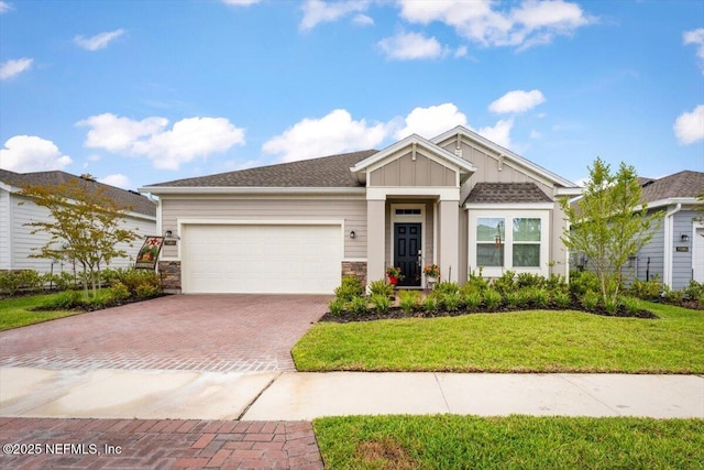 75013 Pondside Ln, Yulee, FL 32097 - view of front of house with decorative driveway, an attached garage, board and batten siding, a front lawn, and stone siding