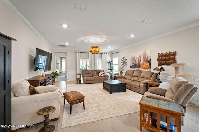 75013 Pondside Ln, Yulee, FL 32097 - living area with crown molding, light wood-style floors, recessed lighting, a chandelier, and a decorative wall