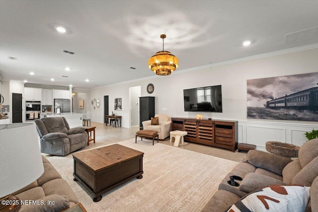75013 Pondside Ln, Yulee, FL 32097 - living area featuring ornamental molding, recessed lighting, a chandelier, a decorative wall, and wainscoting
