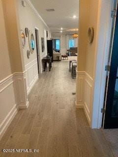 75013 Pondside Ln, Yulee, FL 32097 - hall with a decorative wall, wainscoting, wood finished floors, and crown molding