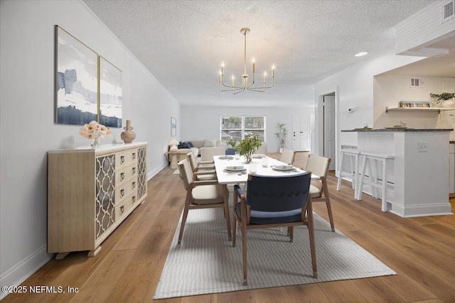 695 A1A Unit 146, Ponte Vedra Beach, FL 32082 - dining space with a chandelier, a textured ceiling, and wood finished floors
