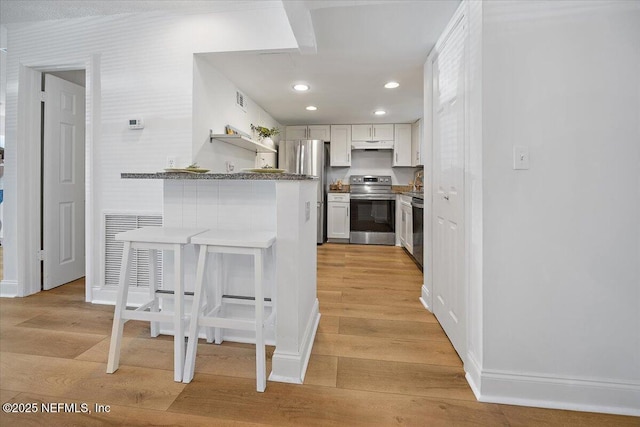 695 A1A Unit 146, Ponte Vedra Beach, FL 32082 - kitchen featuring appliances with stainless steel finishes, light wood-type flooring, a kitchen breakfast bar, a peninsula, and recessed lighting