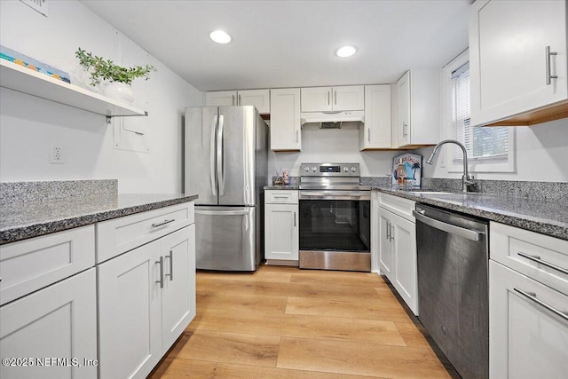695 A1A Unit 146, Ponte Vedra Beach, FL 32082 - kitchen with stainless steel appliances, under cabinet range hood, white cabinets, light wood-style flooring, and recessed lighting