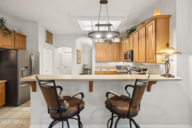 1208 Kyle Way S, Saint Johns, FL 32259 - kitchen featuring stainless steel appliances, light countertops, arched walkways, a peninsula, and a breakfast bar