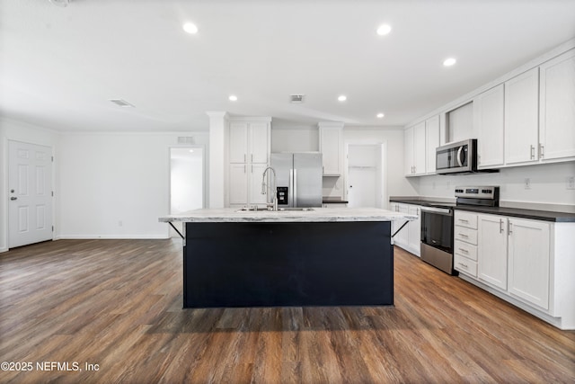 2254 Stauffer Rd, Green Cove Springs, FL 32043 - kitchen featuring stainless steel appliances, a center island with sink, white cabinets, dark wood-style flooring, and recessed lighting