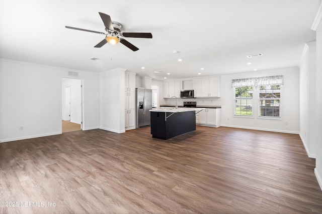 2254 Stauffer Rd, Green Cove Springs, FL 32043 - kitchen with open floor plan, appliances with stainless steel finishes, crown molding, a kitchen island with sink, and recessed lighting