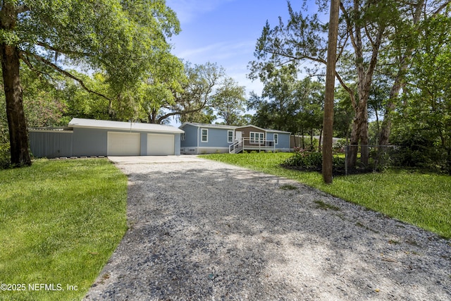 2254 Stauffer Rd, Green Cove Springs, FL 32043 - view of front facade featuring gravel driveway, a garage, and a front lawn