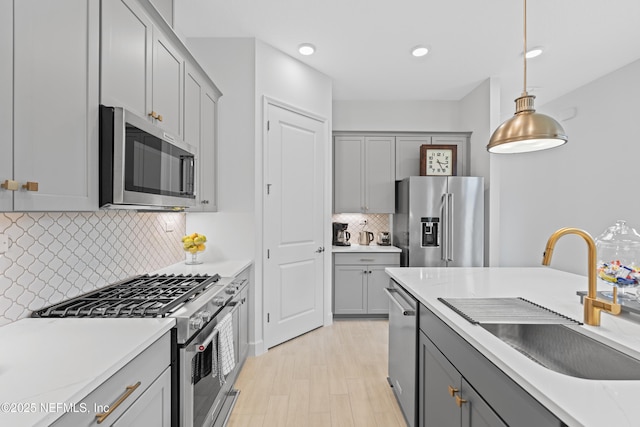 985 Rustic Mill Dr, Saint Augustine, FL 32092 - kitchen featuring stainless steel appliances, gray cabinetry, decorative light fixtures, tasteful backsplash, and light countertops