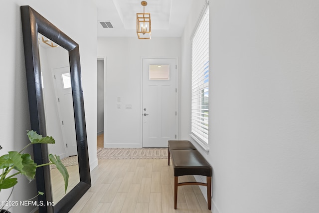 985 Rustic Mill Dr, Saint Augustine, FL 32092 - foyer with light wood finished floors, a tray ceiling, and a chandelier