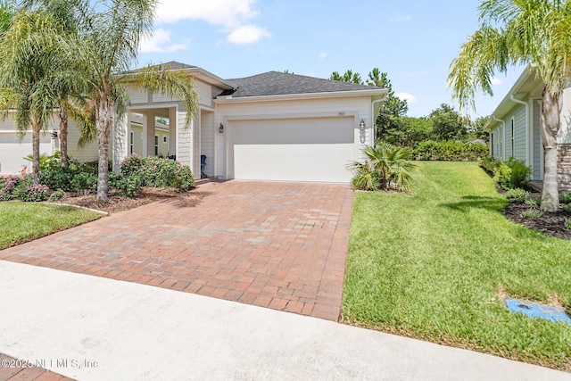 985 Rustic Mill Dr, Saint Augustine, FL 32092 - view of front of property with decorative driveway, an attached garage, a front yard, and a shingled roof
