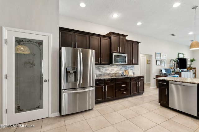 95212 Tanglewood Dr, Fernandina Beach, FL 32034 - kitchen featuring stainless steel appliances, light stone counters, backsplash, dark brown cabinetry, and recessed lighting