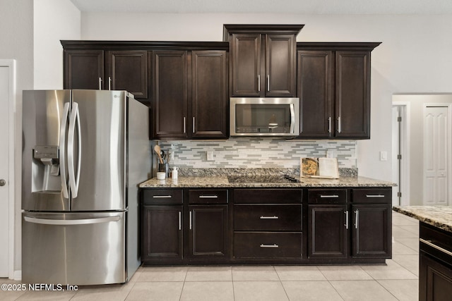 95212 Tanglewood Dr, Fernandina Beach, FL 32034 - kitchen with stainless steel appliances, backsplash, light stone countertops, light tile patterned flooring, and dark brown cabinetry