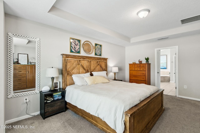95212 Tanglewood Dr, Fernandina Beach, FL 32034 - carpeted bedroom featuring a tray ceiling and ensuite bath