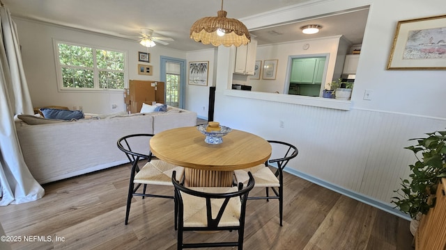1319 Hickory St, Fernandina Beach, FL 32034 - dining area featuring wood finished floors, wainscoting, ceiling fan, and crown molding