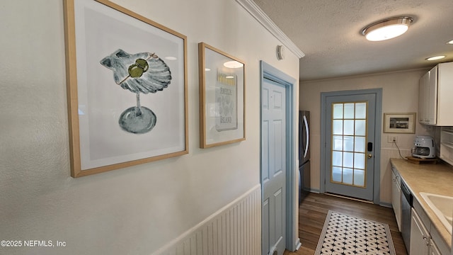 1319 Hickory St, Fernandina Beach, FL 32034 - kitchen featuring dark wood-style flooring, a textured ceiling, crown molding, light countertops, and appliances with stainless steel finishes