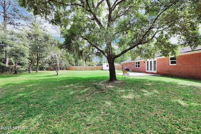 11707 Village Ln, Jacksonville, FL 32223 - fenced backyard with french doors, a shed, and a patio