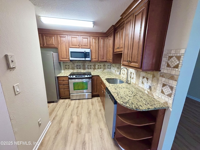 7701 Timberlin Park Blvd Unit 322, Jacksonville, FL 32256 - kitchen featuring stainless steel appliances, light wood finished floors, light stone counters, decorative backsplash, and a textured ceiling
