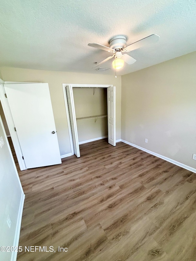 7701 Timberlin Park Blvd Unit 322, Jacksonville, FL 32256 - unfurnished bedroom featuring wood finished floors, a closet, a textured ceiling, and a ceiling fan