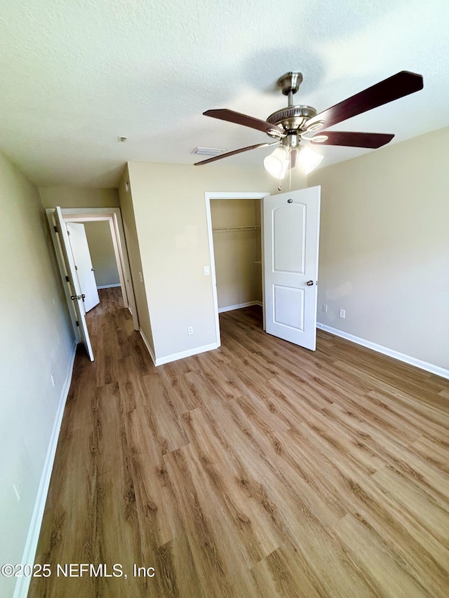 7701 Timberlin Park Blvd Unit 322, Jacksonville, FL 32256 - unfurnished bedroom with wood finished floors, ceiling fan, a closet, a spacious closet, and a textured ceiling