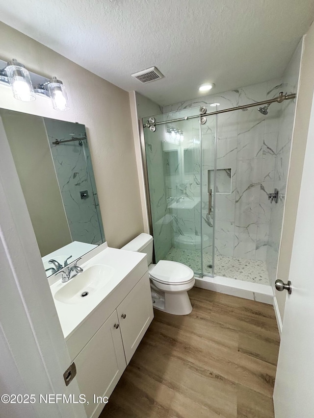 7701 Timberlin Park Blvd Unit 322, Jacksonville, FL 32256 - full bath with a marble finish shower, a textured ceiling, vanity, and wood finished floors