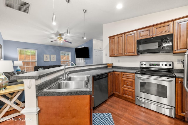 122 Twine St, Saint Augustine, FL 32084 - kitchen with stainless steel appliances, open floor plan, a peninsula, dark countertops, and brown cabinetry