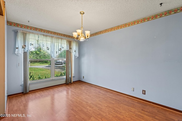 1083 Kings Rd, Neptune Beach, FL 32266 - empty room with a chandelier, wood finished floors, and a textured ceiling