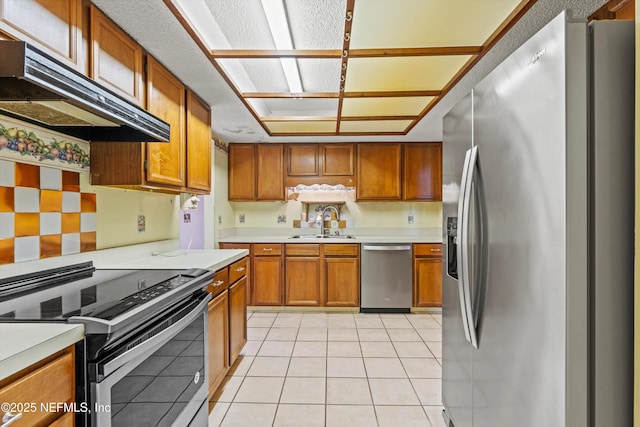 1083 Kings Rd, Neptune Beach, FL 32266 - kitchen with stainless steel appliances, under cabinet range hood, brown cabinetry, light countertops, and light tile patterned floors