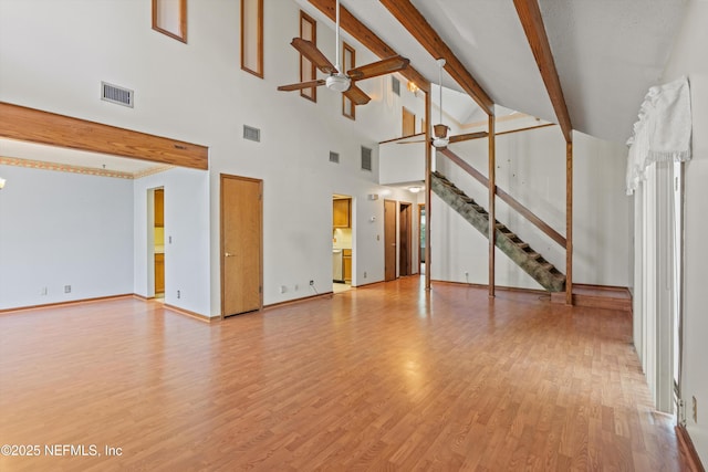 1083 Kings Rd, Neptune Beach, FL 32266 - unfurnished living room with ceiling fan, light wood-style floors, stairs, high vaulted ceiling, and beamed ceiling