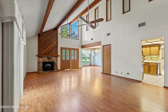 1083 Kings Rd, Neptune Beach, FL 32266 - unfurnished living room with a ceiling fan, light wood finished floors, beamed ceiling, high vaulted ceiling, and a fireplace