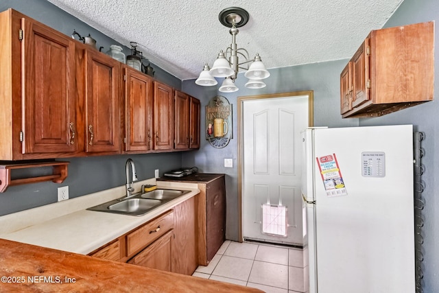 2259 Marlee Rd S, Jacksonville, FL 32259 - kitchen featuring freestanding refrigerator, a chandelier, a textured ceiling, light tile patterned floors, and light countertops