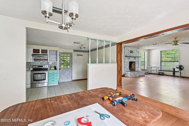 2259 Marlee Rd S, Jacksonville, FL 32259 - unfurnished dining area with a fireplace, a ceiling fan, a textured ceiling, and tile patterned flooring