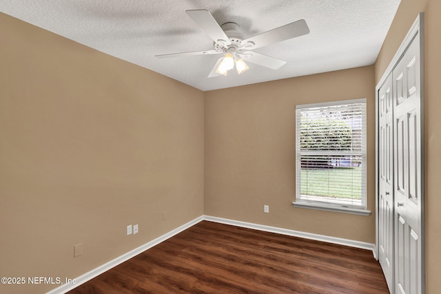1994 Protection Pt, Fleming Island, FL 32003 - unfurnished bedroom featuring dark wood-style flooring, a closet, a textured ceiling, and a ceiling fan
